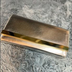 Silver clutch w/ gold chain shoulder strap and gold trim on clutch